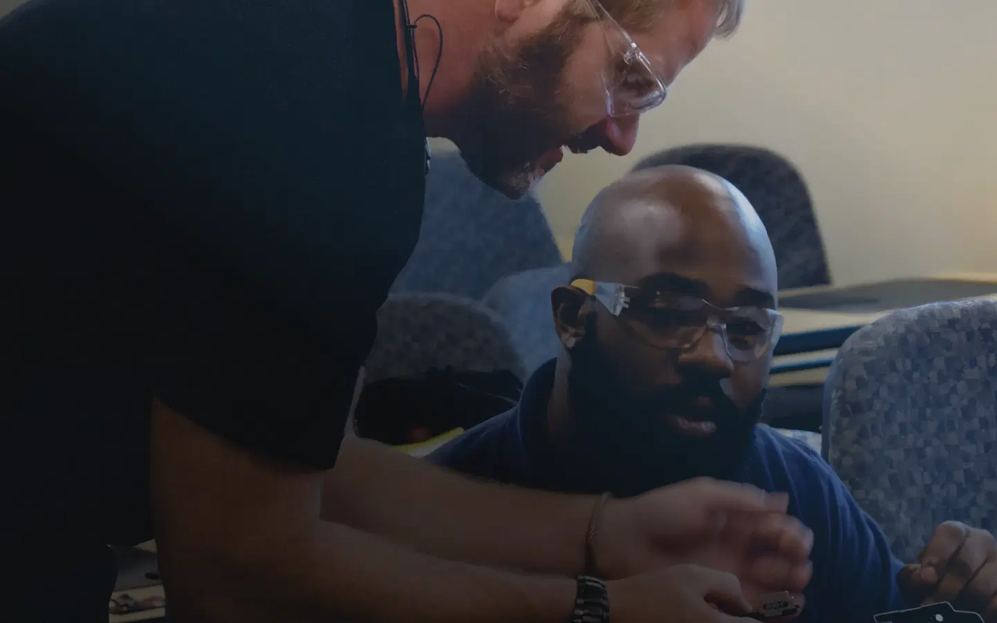 Instructor guiding a student during hands-on fiber optic training
